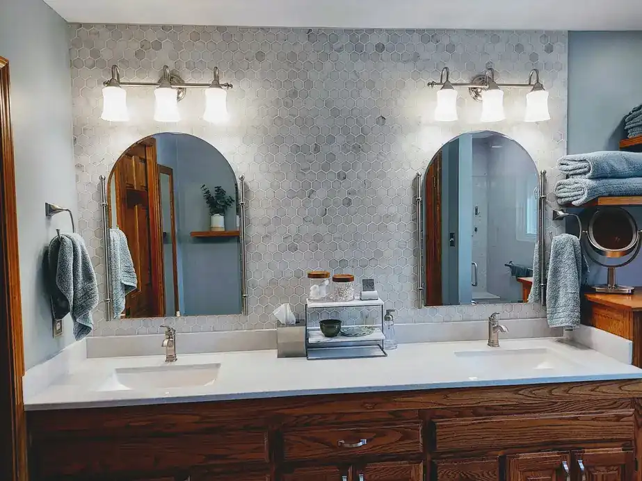 Bathroom with a double vanity, hex tile floor and two arched mirrors
