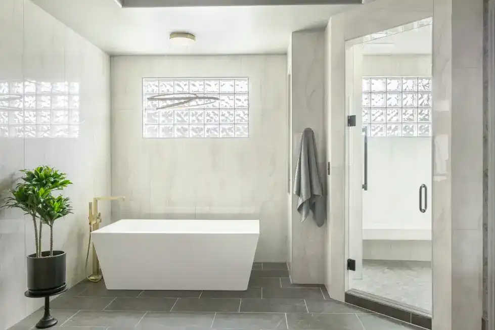 The same primary bath after the PDQ remodel, with new tile, glass and fixtures