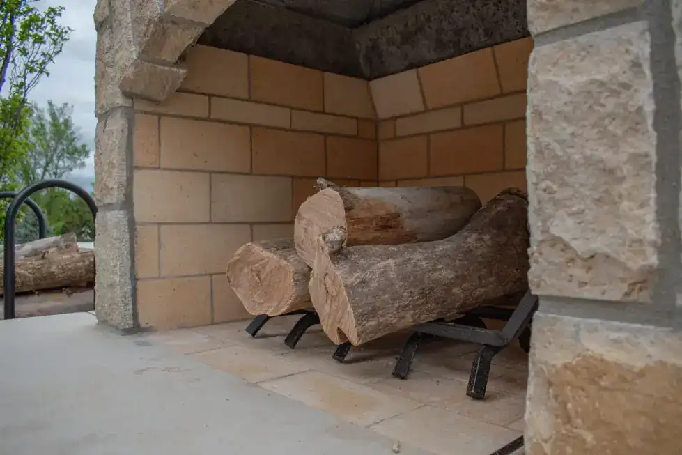 Stacked stone fireplace with a log rack laid by the PDQ masonry crew
