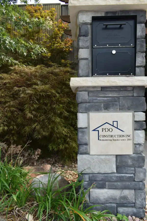 The stone mailbox pillar PDQ's masons built, carrying the PDQ sign
